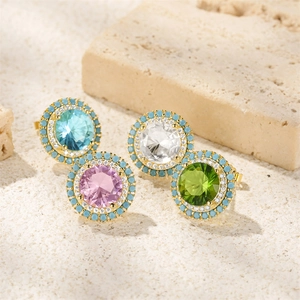 Macro shot of four colorful round turquoise studs with diamonds on natural stone base