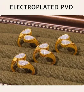Detail of PVD gold plated double pear-cut zircon rings on olive green velvet display