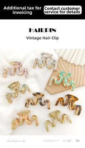 Close-up of retro acetate hair claws with shell patterns and gold metal clips