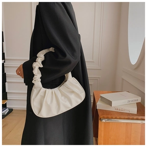 Detailed side view of white pleated cloud bag with stylish crescent moon design