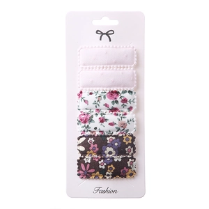 Detailed view of six floral embroidery fabric hair clips with wavy rectangle edges