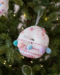 Close-up of donut-shaped Christmas ornament with colorful beads and pom poms on a tree