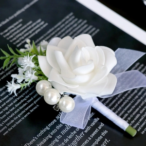 Elegant white artificial rose boutonniere with pearls and ribbon for wedding ceremony
