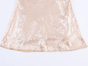 Détails des paillettes champagne scintillantes sur l'ourlet d'une robe sirène