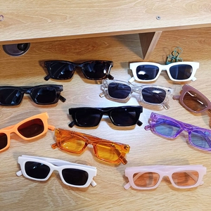 Flat lay of retro square sunglasses in multiple colors on a wooden surface