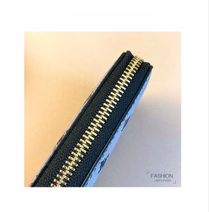 Detailed close-up of premium gold zipper and printed pattern on light blue lady's purse