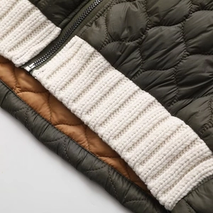 Detailed close-up of metal zipper and diamond quilted texture on a knit patchwork jacket