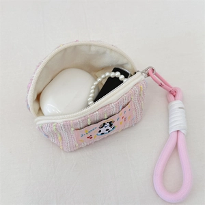 Detail of pink tweed earphone pouch with cartoon cow patch and hanging rope