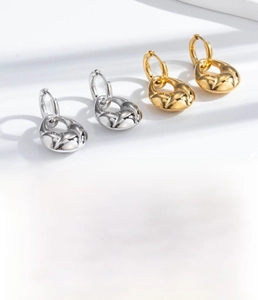 Detailed view of gold and silver croissant earrings made of vacuum-plated titanium steel