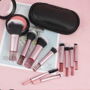 Flat lay of 10 pink makeup brushes with gradient bristles and a black PU zipper pouch