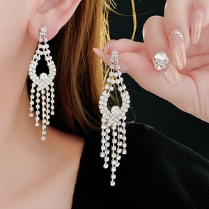 Close-up of silver tassel earrings with sparkling rhinestones worn by a model
