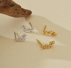 Detailed view of gold and silver S925 sterling silver star stud earrings with cubic zirconia