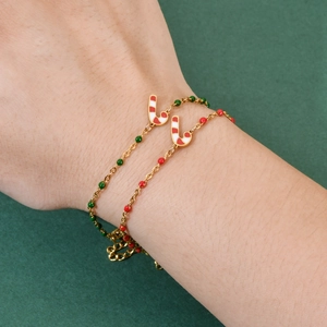 Christmas gold chain bracelet with candy cane charm and red green beads on wrist
