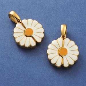 Macro view of gold daisy pendants with white enamel petals and yellow center detail