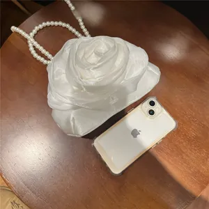 Macro shot of white 3D rose fabric texture and pearl strap on bridal evening bag