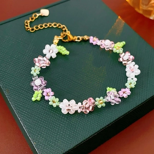 Detailed macro view of handmade floral resin bead bracelet with golden heart pendant