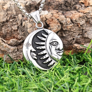 Detail of sun and moon pendant with relief carving on a stainless steel square chain