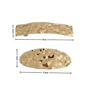 Detail of gold metal hair clips with hammered texture surface and size annotations