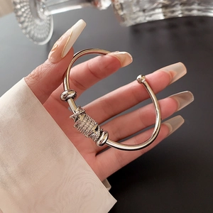 Close-up of a silver open bangle featuring sparkling cubic zirconia on a female hand