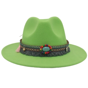 Detail of light green western cowboy hat featuring turquoise stone and bohemian tassel trim