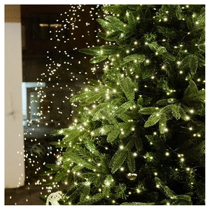 Close-up of warm white LED firefly lights on a green Christmas tree branches