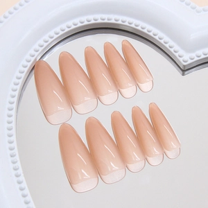Glossy nude gradient almond press-on nails with pearl shimmer finish on heart mirror