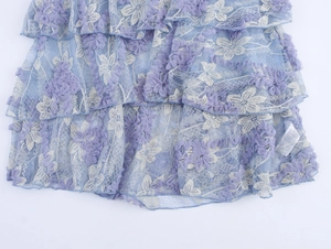 Détail de jupe bohème en dentelle bleu-violet avec broderies florales 3D et volants