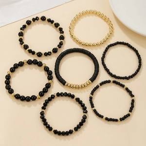 Detail of 7-piece bohemian black and gold acrylic bead stretch bracelets for women