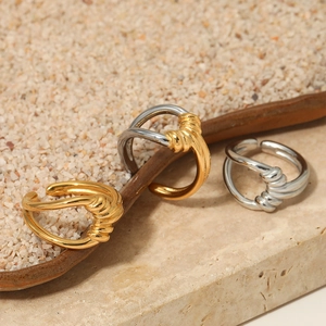 Minimalist twisted knot open rings in gold and silver finish on elegant marble stone