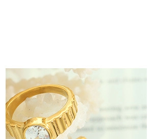 Détail d'une bague en titane doré avec texture verticale et pierre de mer ronde