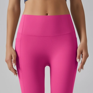 Detail of high-waist fuchsia yoga leggings with side pockets and elastic waist design