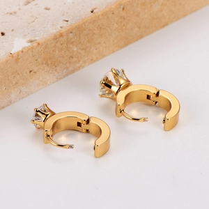 Detail of gold hinged hoop earrings featuring a prong-set clear zircon on a stone base