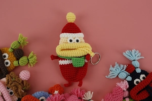 Close-up of handmade crochet sausage mouth key case in red yarn with metal ring