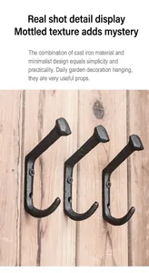 Detail of vintage cast iron hooks in J-shape mounted on a rustic wood board