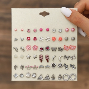 Close-up of 30 pairs earring set featuring silver and pink butterfly and floral studs