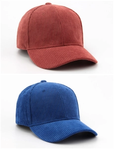 Close-up of corduroy texture on reddish-brown and blue baseball caps with soft lighting