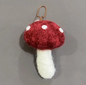 Dettaglio di un fungo in feltro rosso fatto a mano con puntini bianchi per Natale