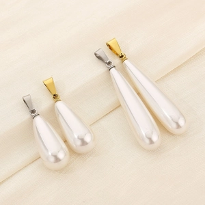 Detailed view of four teardrop pearl pendants in gold and silver finishes on fabric
