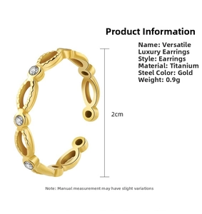 Detailed view of wave-shaped gold titanium earrings with three clear zircons, 2cm diameter