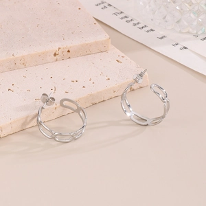 Vue rapprochée de boucles d'oreilles argentées évidées sur un support en pierre élégant