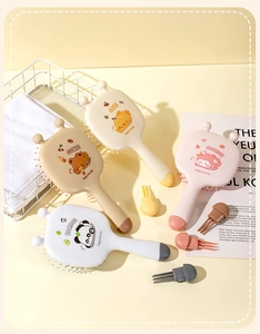 Detail view of four cute cartoon bee air cushion hairbrushes with soft cleaning tools