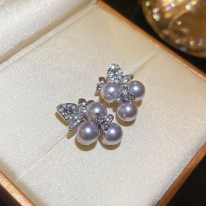 Macro detail of lavender pearl butterfly studs with diamonds in a gift box