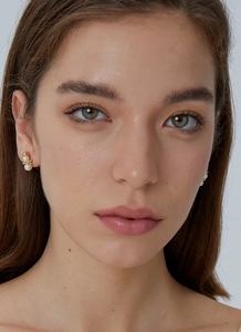 Close-up of elegant gold-plated snowman earrings with white pearls on a model