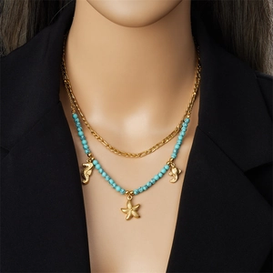 Double-layered gold necklace with turquoise beads and seahorse starfish fish pendants