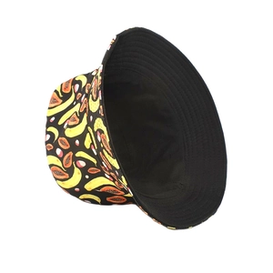 Detail of reversible bucket hat featuring vibrant banana and papaya prints on black cotton