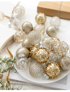 Detailed view of assorted gold and white Christmas baubles in a white decorative bowl