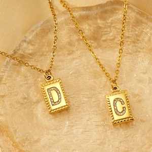 Detail of 18k gold plated square pendant necklaces with crystal paved D and C letters