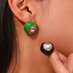 Gros plan de boucles d'oreilles cœur en émail avec zircone portées par un mannequin