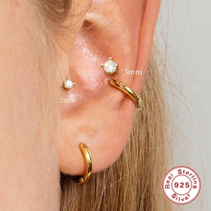 S925 sterling silver four-prong stud earrings with clear zircon stones on ear