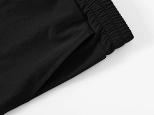 Detail of black cargo shorts featuring elastic waistband and reinforced side pockets